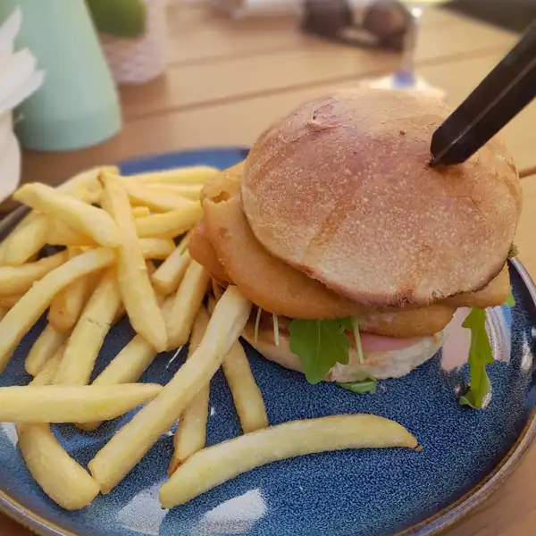Burger i frytki na niebieskim talerzu