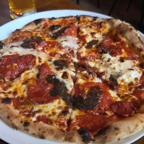 Pizza z salami i oliwkami na stole